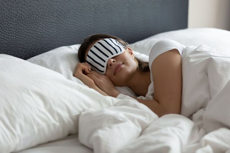 Donna dorme nel letto con mascherina occhi