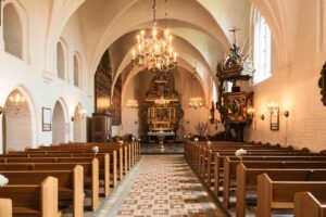 Interno di una chiesa con vista sul corridoio centrale verso l'altare