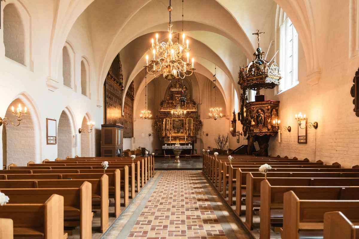 Interno di una chiesa con vista sul corridoio centrale verso l'altare