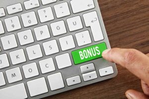 tastiera pc in primo piano e dito su tasto bonus