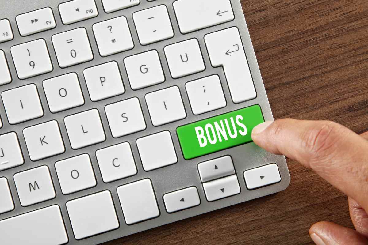tastiera pc in primo piano e dito su tasto bonus