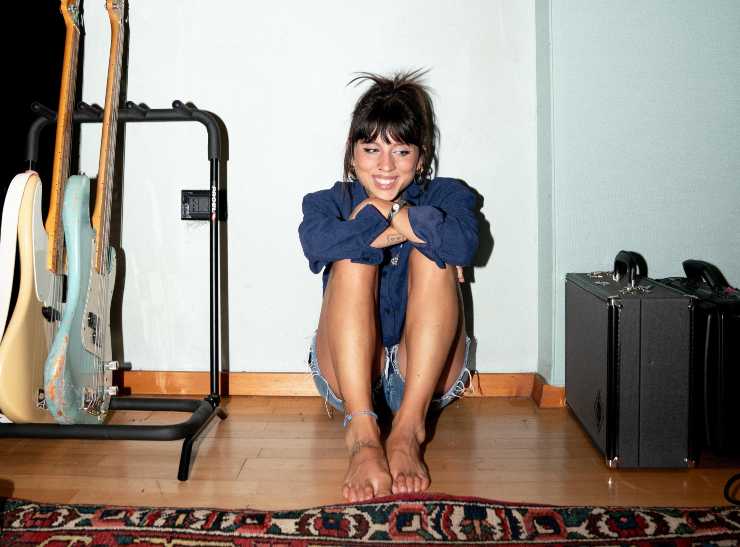 Angelina Mango seduta per terra sorridente