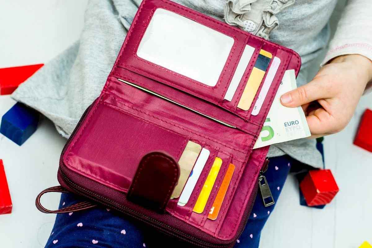 Donna che esce banconota da 5 euro dal portafoglio