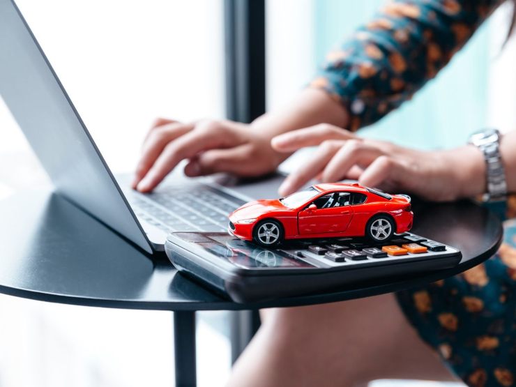donna al pc con calcolatrice e modellino auto
