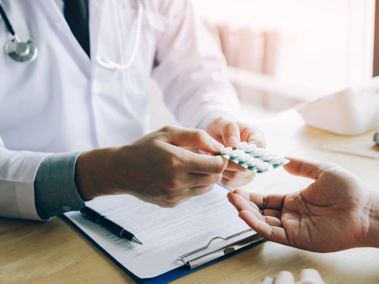 Dottore che consegna dei farmaci al paziente