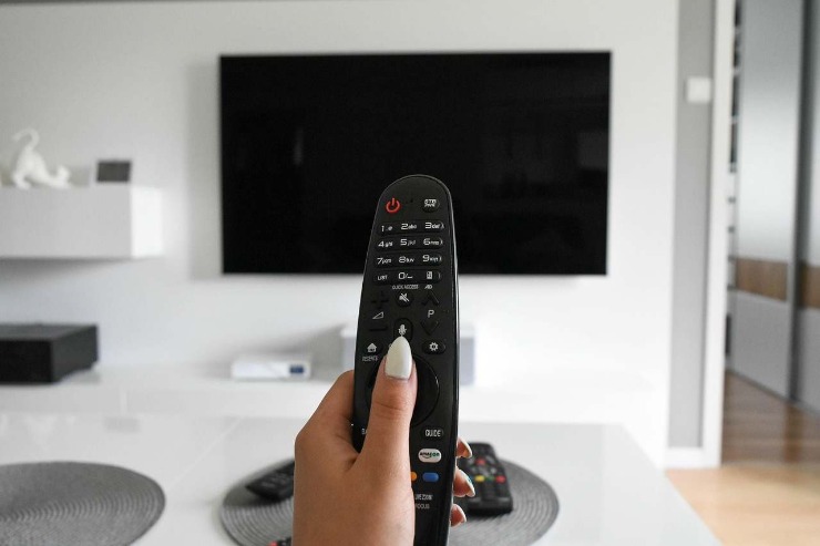 Donna che accente la tv con un telecomando