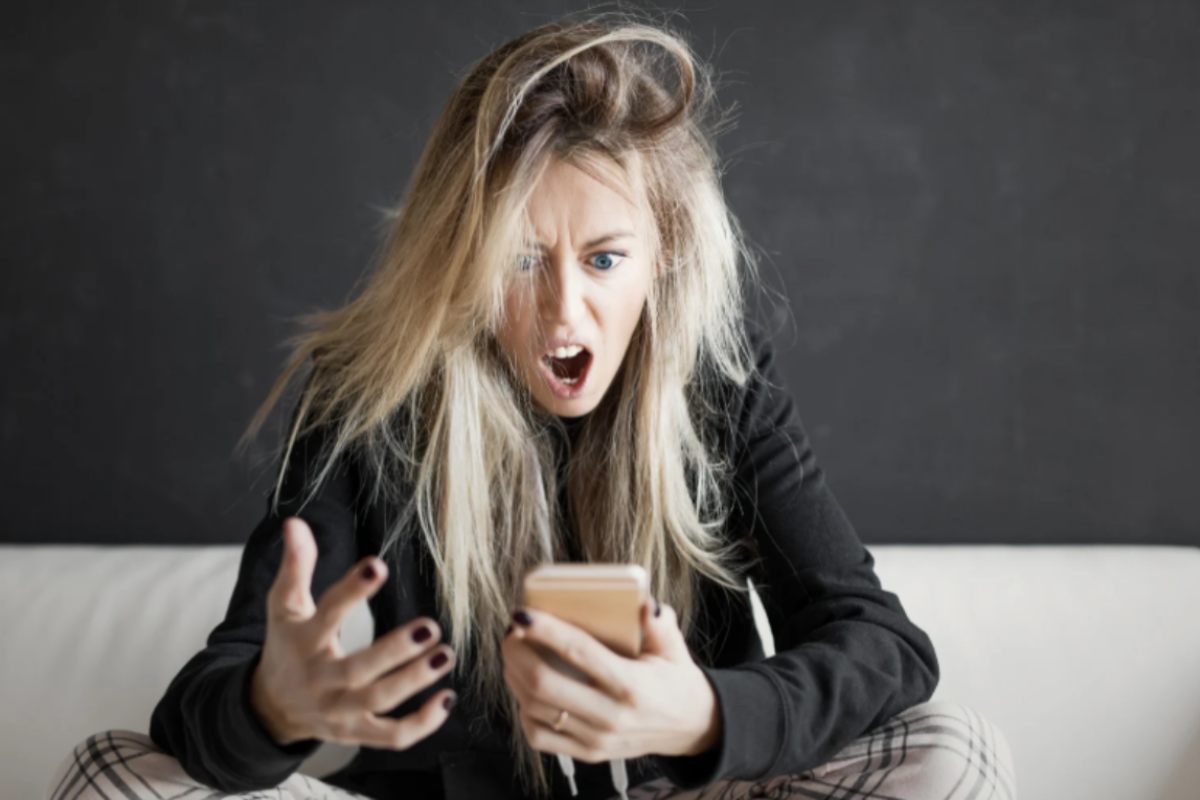 donna arrabbiata con il cellulare in mano