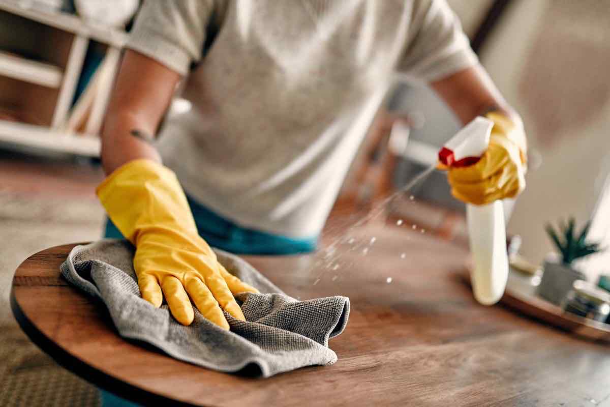 Persona che pulisce un tavolo