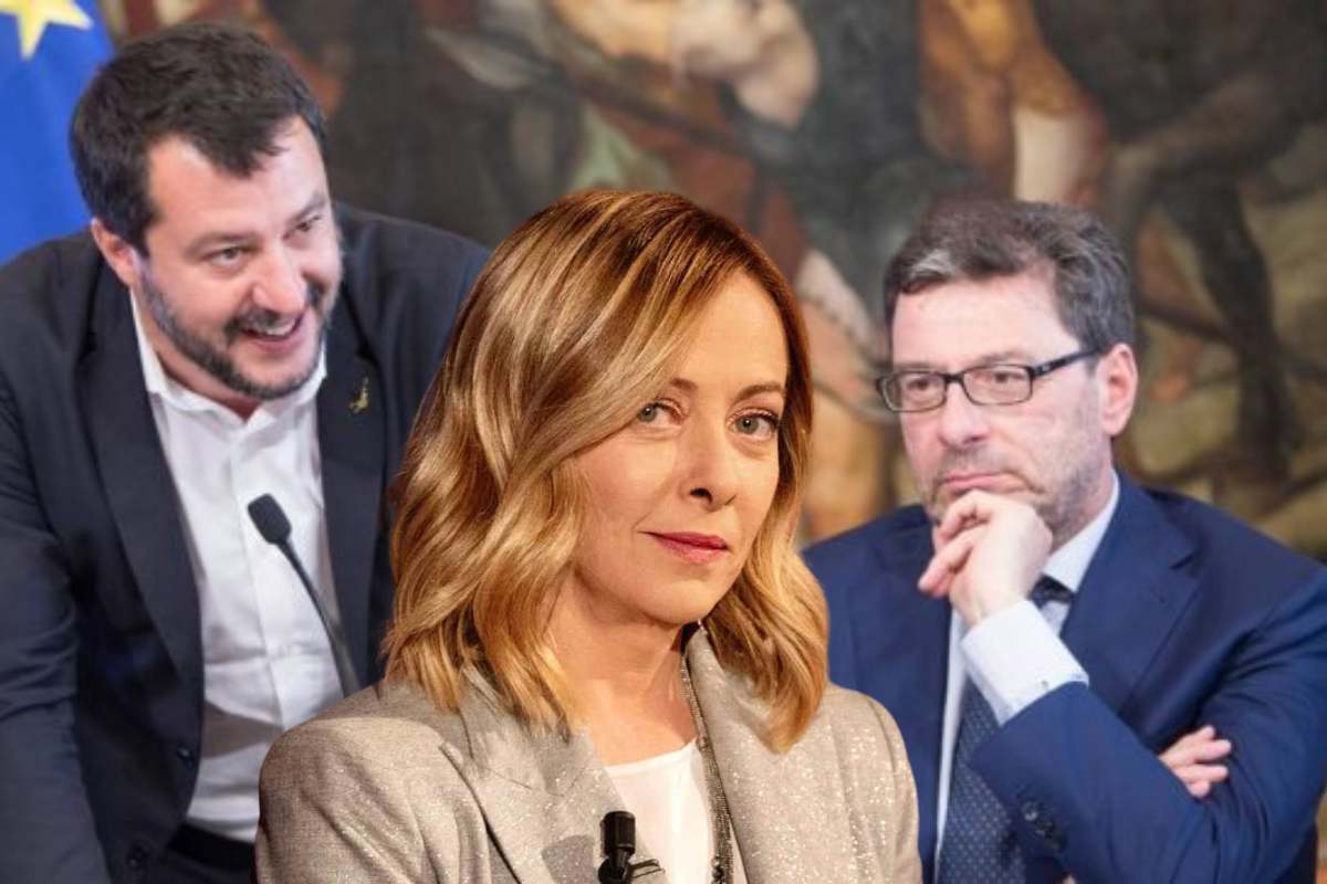 giorgia meloni e sullo sfondo giorgetti e salvini