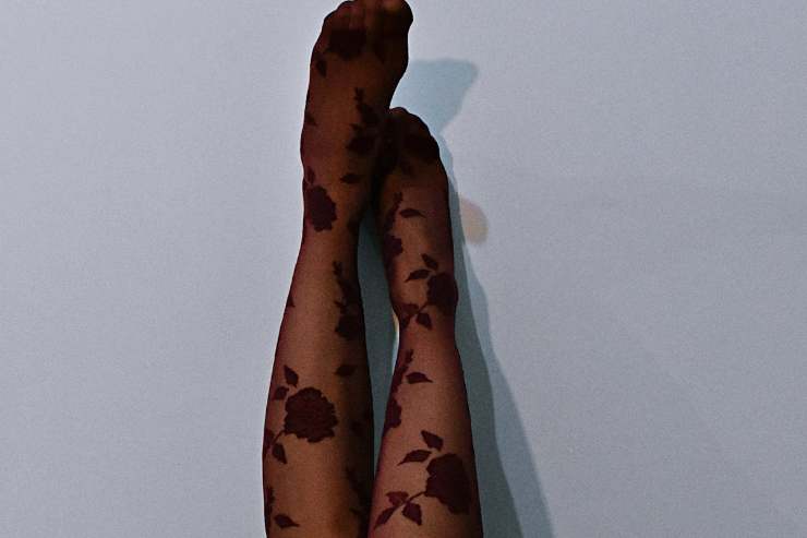 Gambe di donna poggiate su una parete