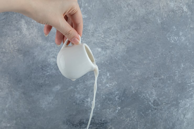 Latte versato da un bricco di porcellana