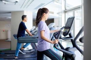 Donna che corre sul tapis roulant in palestra