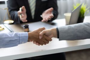 due uomini si danno la mano in segno di pace davanti a giudice