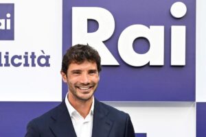 Stefano De Maetino sorride con logo Rai alle spalle