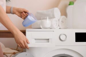 Donna con detersivo per lavatrice in polvere